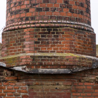 Příklop podstavce procházel střechou, za povšimnutí stojí tvarovkami zdobený přechod mezi maticí soklu a dříkem s kruhovým profilem.